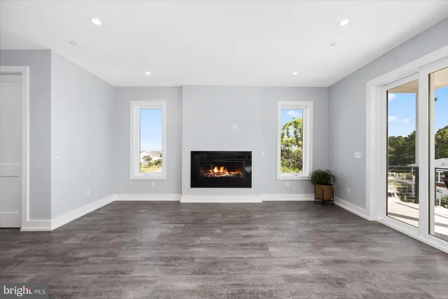 an empty room with wooden floor and fireplace