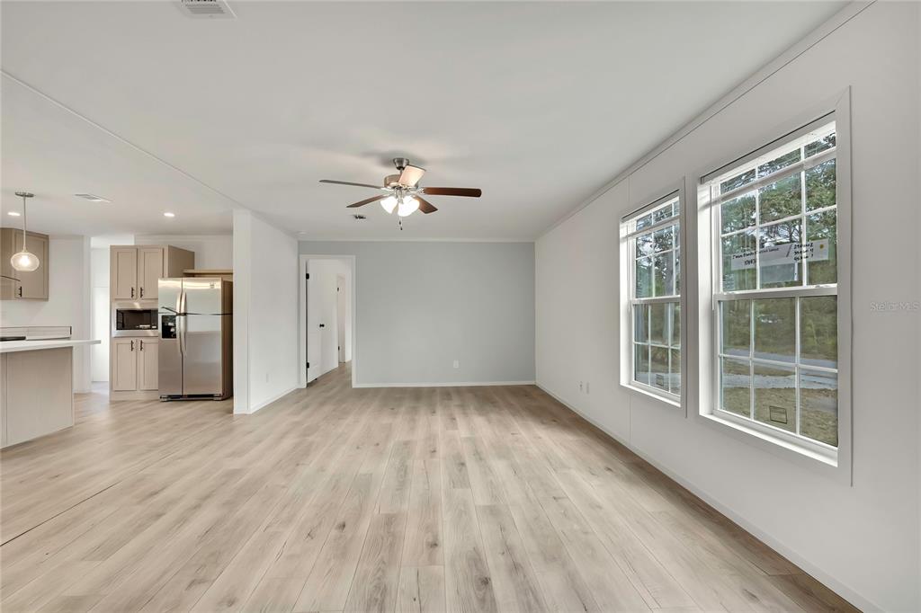 5342 South Isabel Terrace Homosassa, FL 34446 - Photo 11 of 23 a view of empty room with wooden floor and kitchen