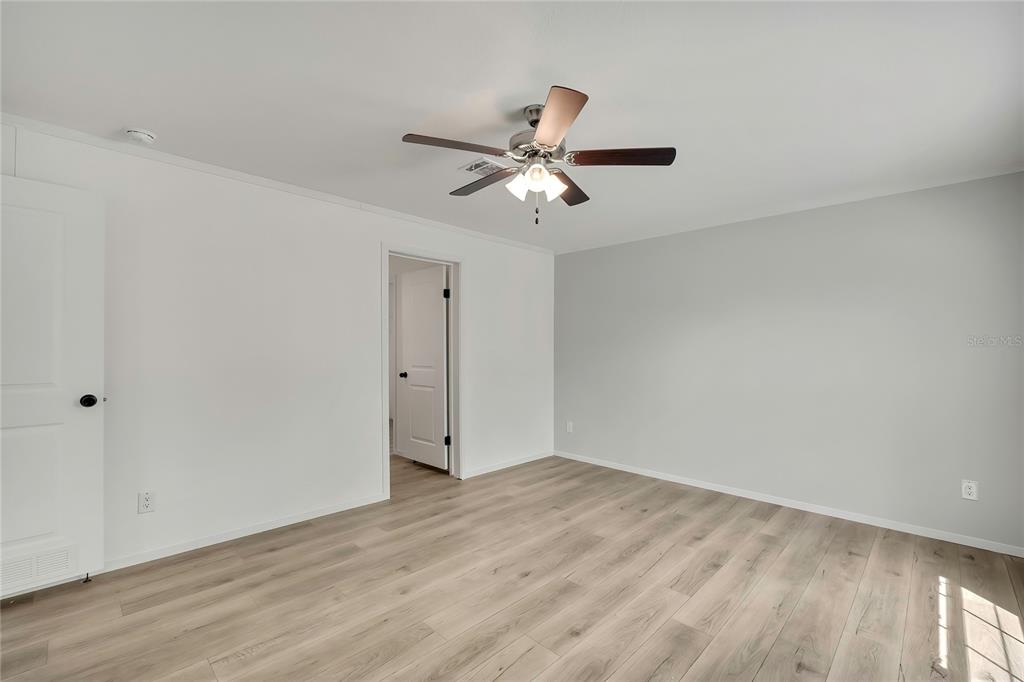 5342 South Isabel Terrace Homosassa, FL 34446 - Photo 15 of 23 a view of a room with wooden floor and a ceiling fan