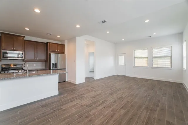 a kitchen with stainless steel appliances granite countertop a refrigerator and a stove top oven