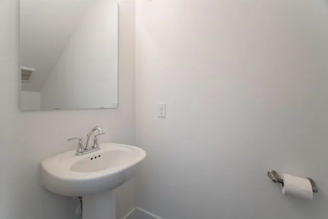 a white sink sitting under a bathroom mirror