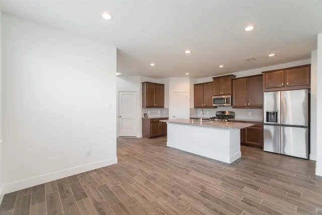 a kitchen with a refrigerator and white cabinets