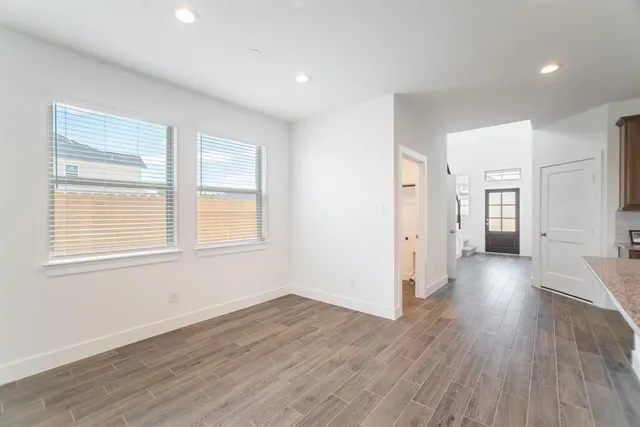 a view of a big room with wooden floor and windows