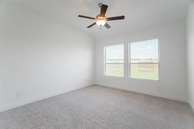 an empty room with a window and a fan