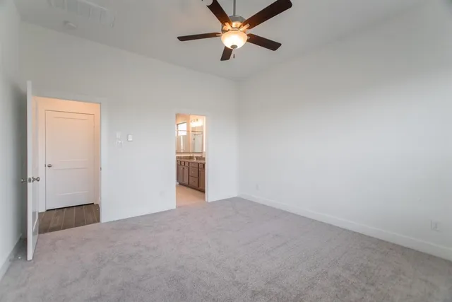a view of an empty room and a ceiling fan window