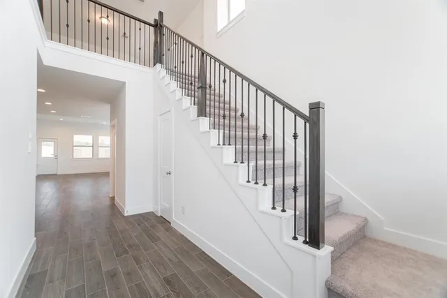 a view of staircase with railing and white walls