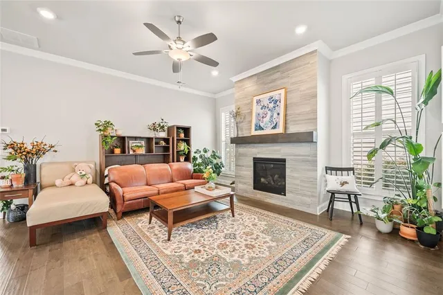 a large kitchen with kitchen island a stove a sink a refrigerator and white cabinets with wooden floor