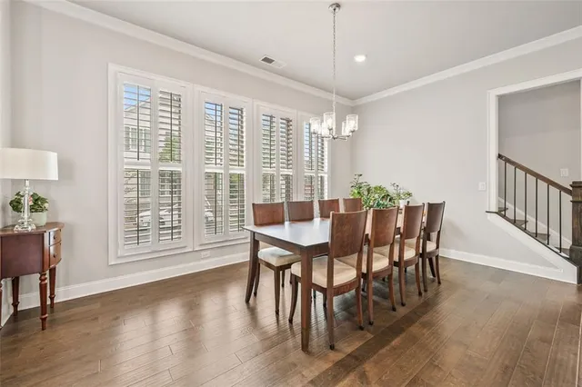 a large white kitchen with center island and stainless steel appliances