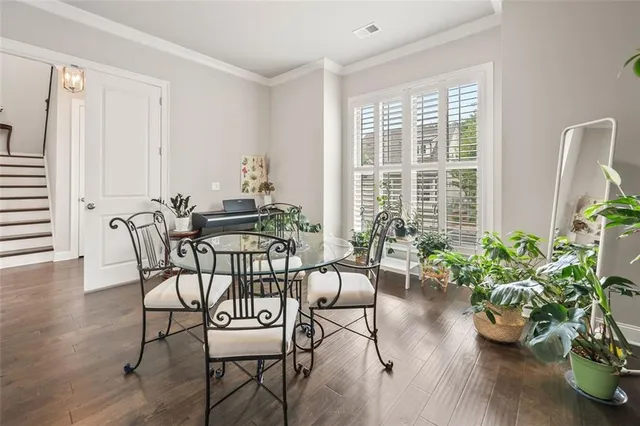 a dining room with furniture potted plants and wooden floor