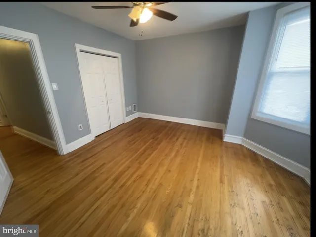 a view of empty room with wooden floor