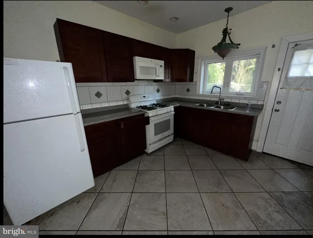 a kitchen with a refrigerator a stove a microwave and cabinets