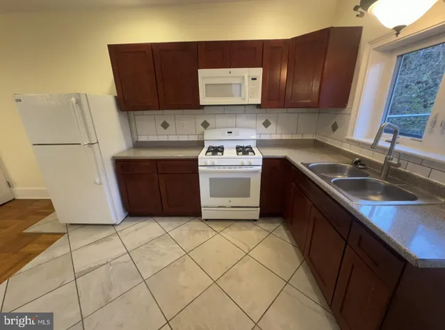 a kitchen with a sink a stove and cabinets