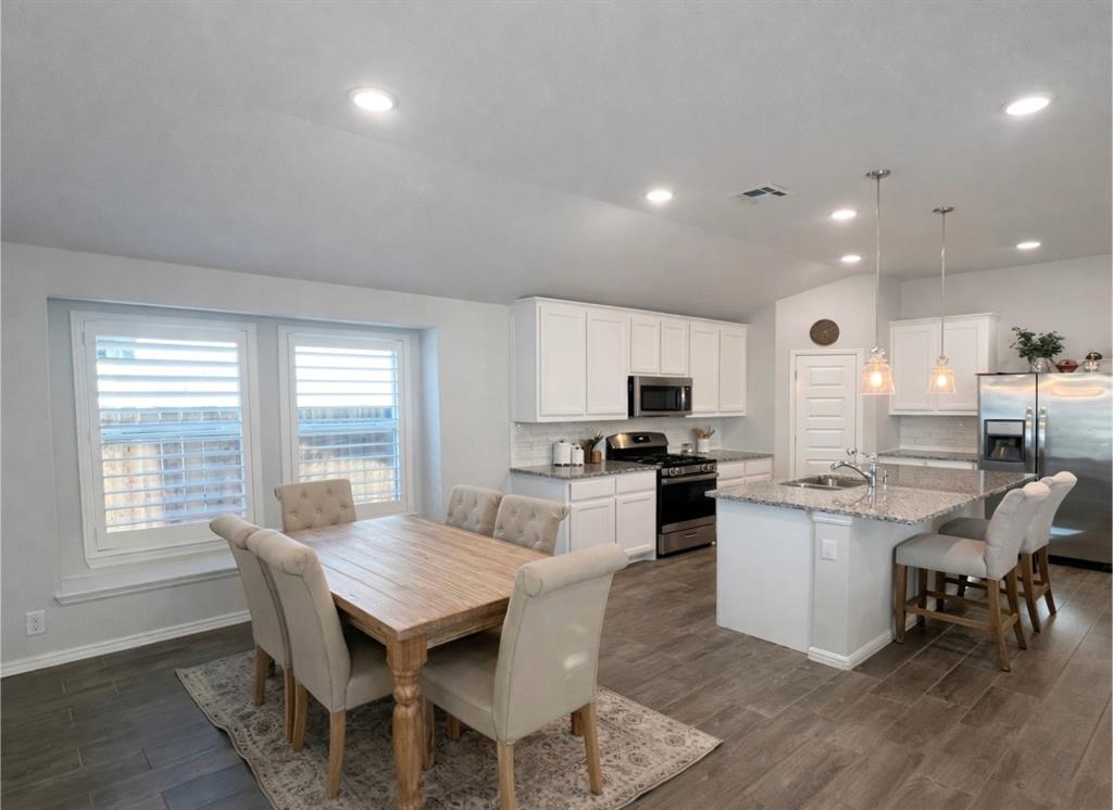 6609 Adderly Road Pilot Point, TX 76258 - Photo 3 of 15 a kitchen with a dining table chairs and flat screen tv