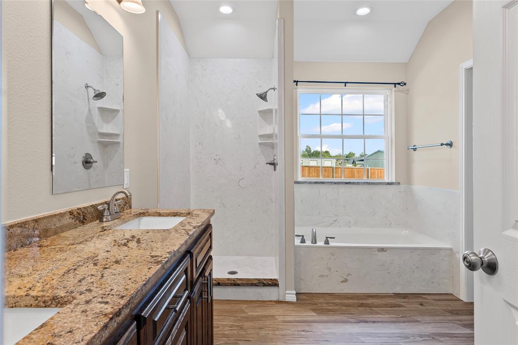 2910 Monroe Street Commerce, TX 75428 - Photo 16 of 34 a bathroom with a granite countertop sink a mirror and shower