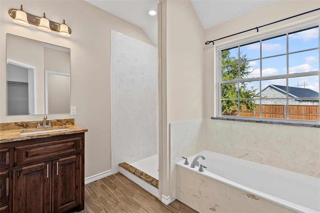 2910 Monroe Street Commerce, TX 75428 - Photo 17 of 34 a bathroom with a tub a sink and a window