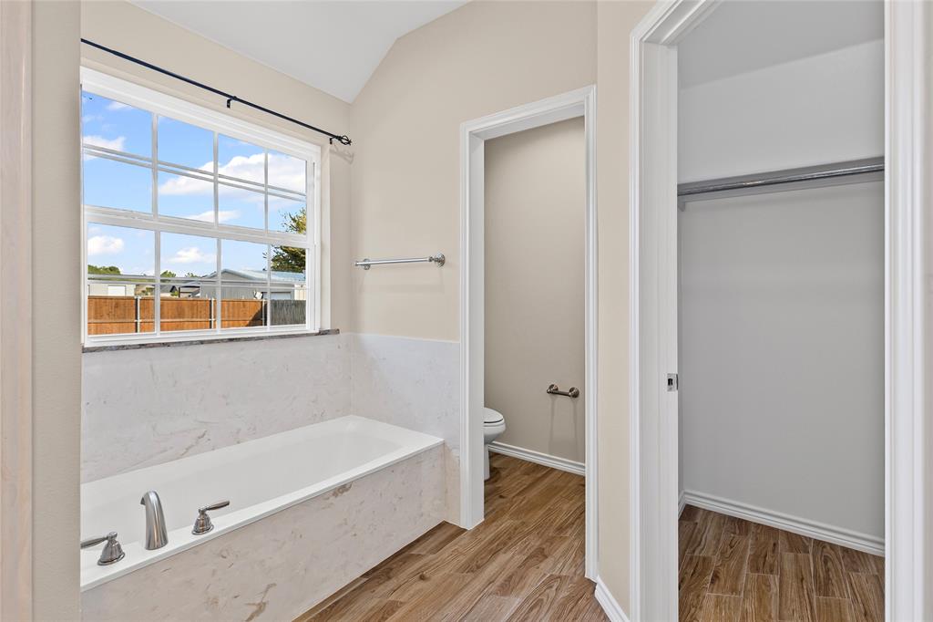 2910 Monroe Street Commerce, TX 75428 - Photo 18 of 34 a bathroom with a bathtub and a shower
