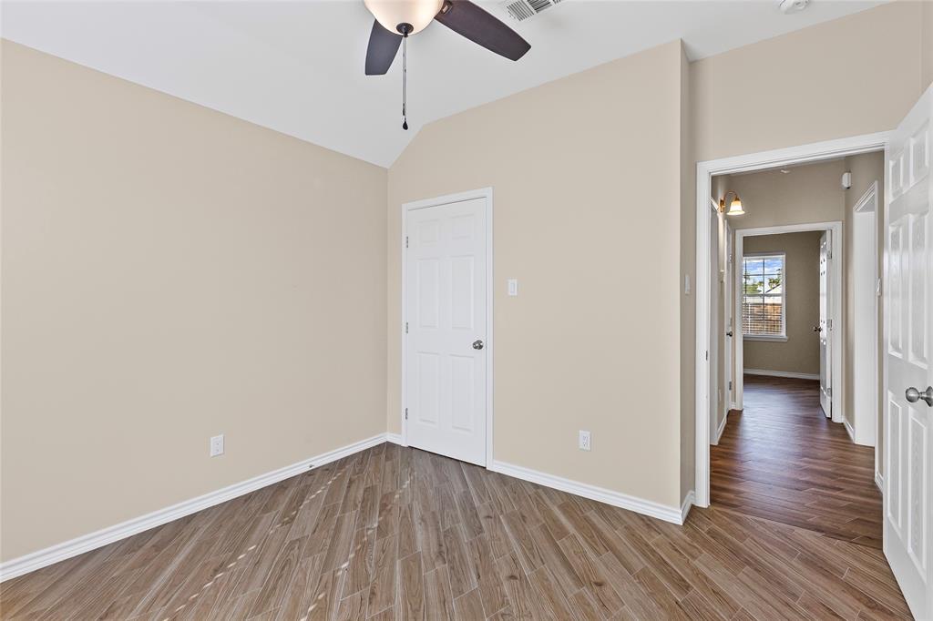 2910 Monroe Street Commerce, TX 75428 - Photo 21 of 34 an empty room with wooden floor a chandelier fan and wooden floor