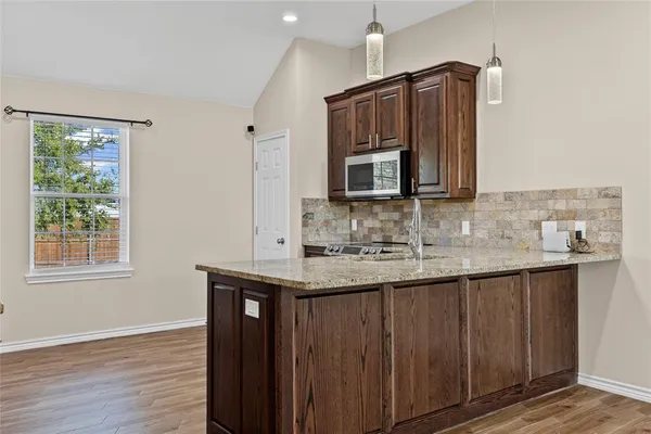 a kitchen with stainless steel appliances granite countertop a sink stove and cabinets