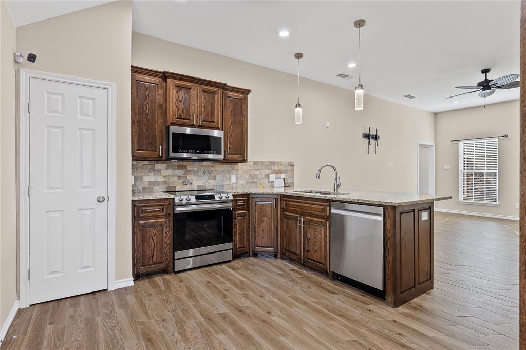 2910 Monroe Street Commerce, TX 75428 - Photo 7 of 34 a kitchen with granite countertop a stove and a sink