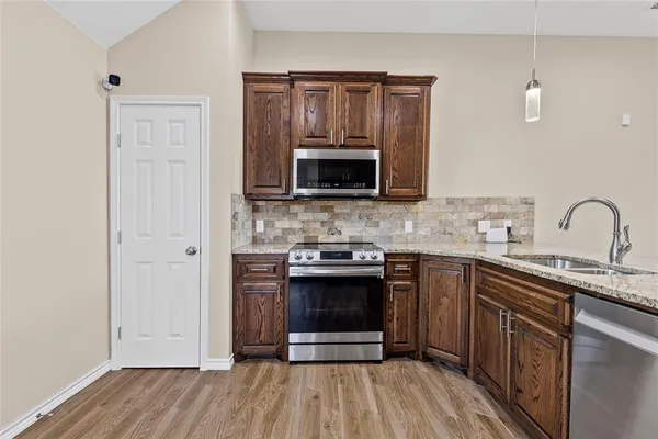 a kitchen with sink a microwave and cabinets