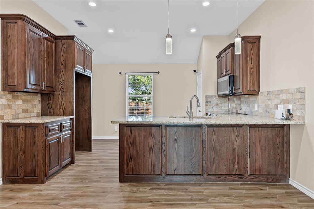 2910 Monroe Street Commerce, TX 75428 - Photo 9 of 34 a kitchen with stainless steel appliances granite countertop a sink stove and refrigerator