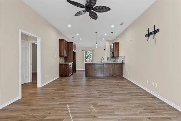 a view of a kitchen with wooden floor and a ceiling fan