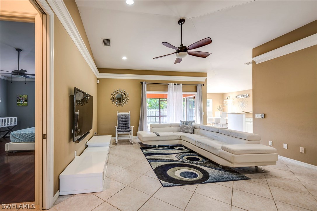 9036 Henry Road Fort Myers, FL 33967 - Photo 3 of 22 a spacious bedroom with a bed and a chandelier