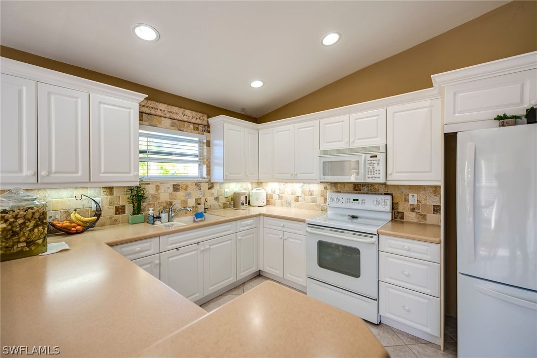 9036 Henry Road Fort Myers, FL 33967 - Photo 7 of 22 a kitchen with white cabinets and white appliances