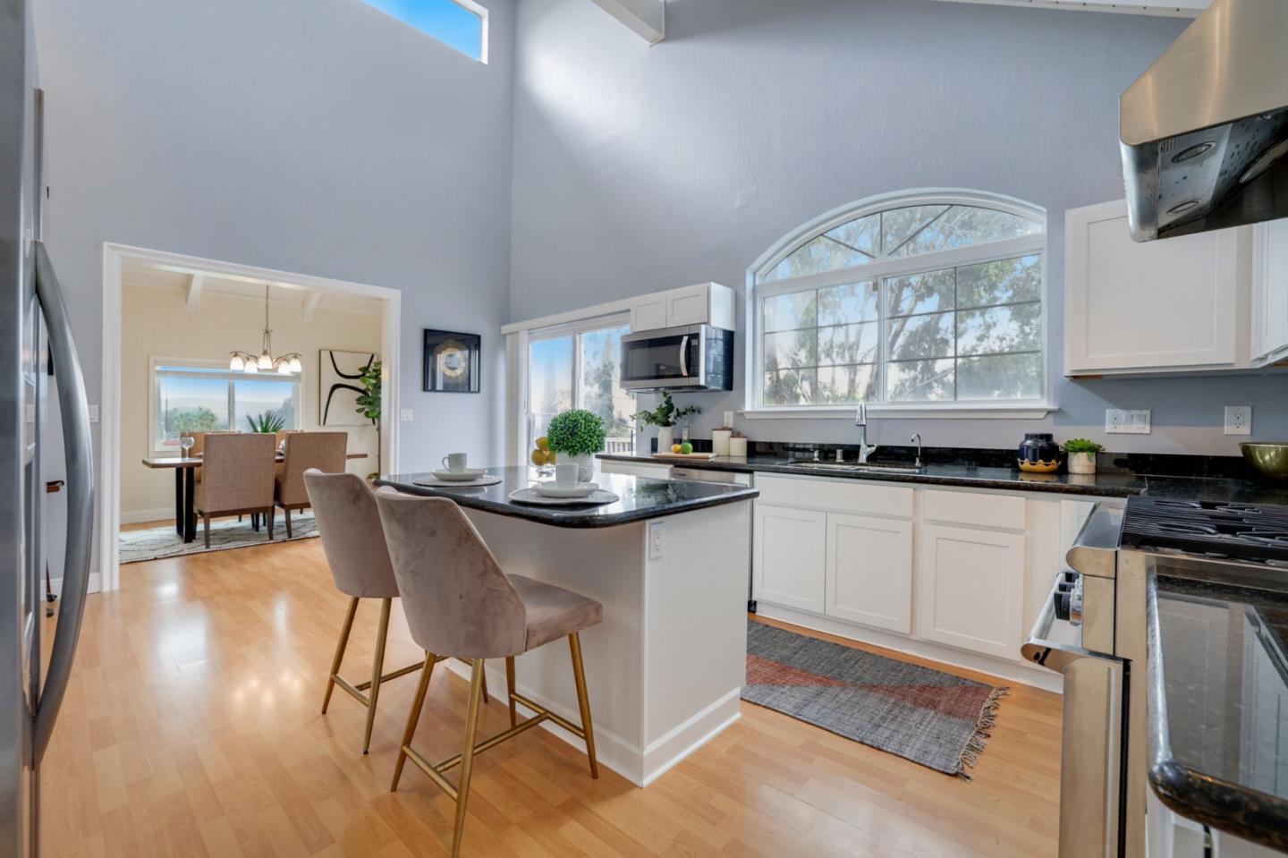 3303 Americus Drive San Jose, CA 95148 - Photo 14 of 51 a kitchen with stainless steel appliances granite countertop a stove top oven a sink a dining table and chairs with wooden floor