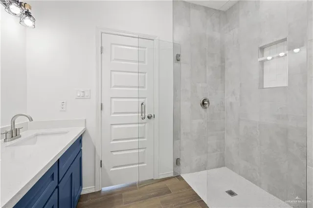 a bathroom with a shower a sink and a mirror