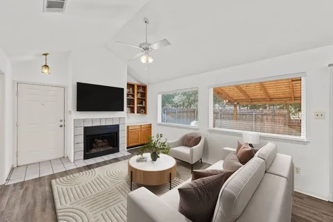 a living room with furniture a flat screen tv and a fireplace