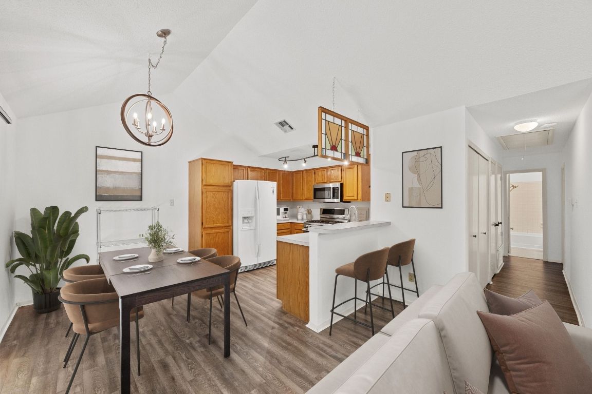 11901 Swearingen Drive, Unit 39 Austin, TX 78758 - Photo 8 of 25 a view of a dining room with furniture a chandelier and wooden floor