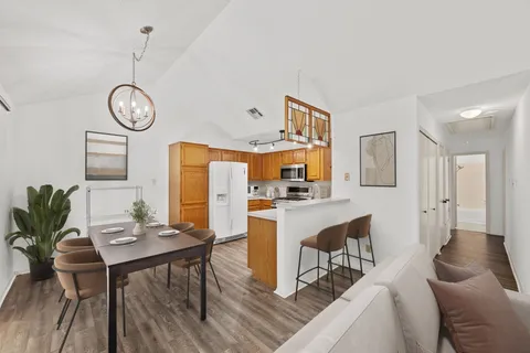 a view of a dining room with furniture a chandelier and wooden floor
