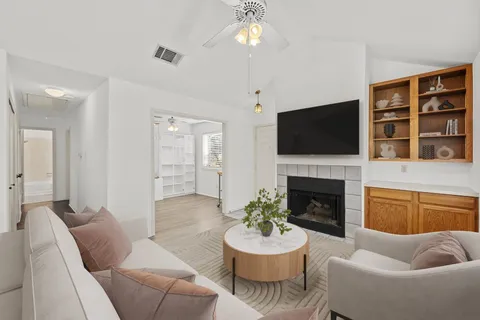a living room with furniture a fireplace and a flat screen tv