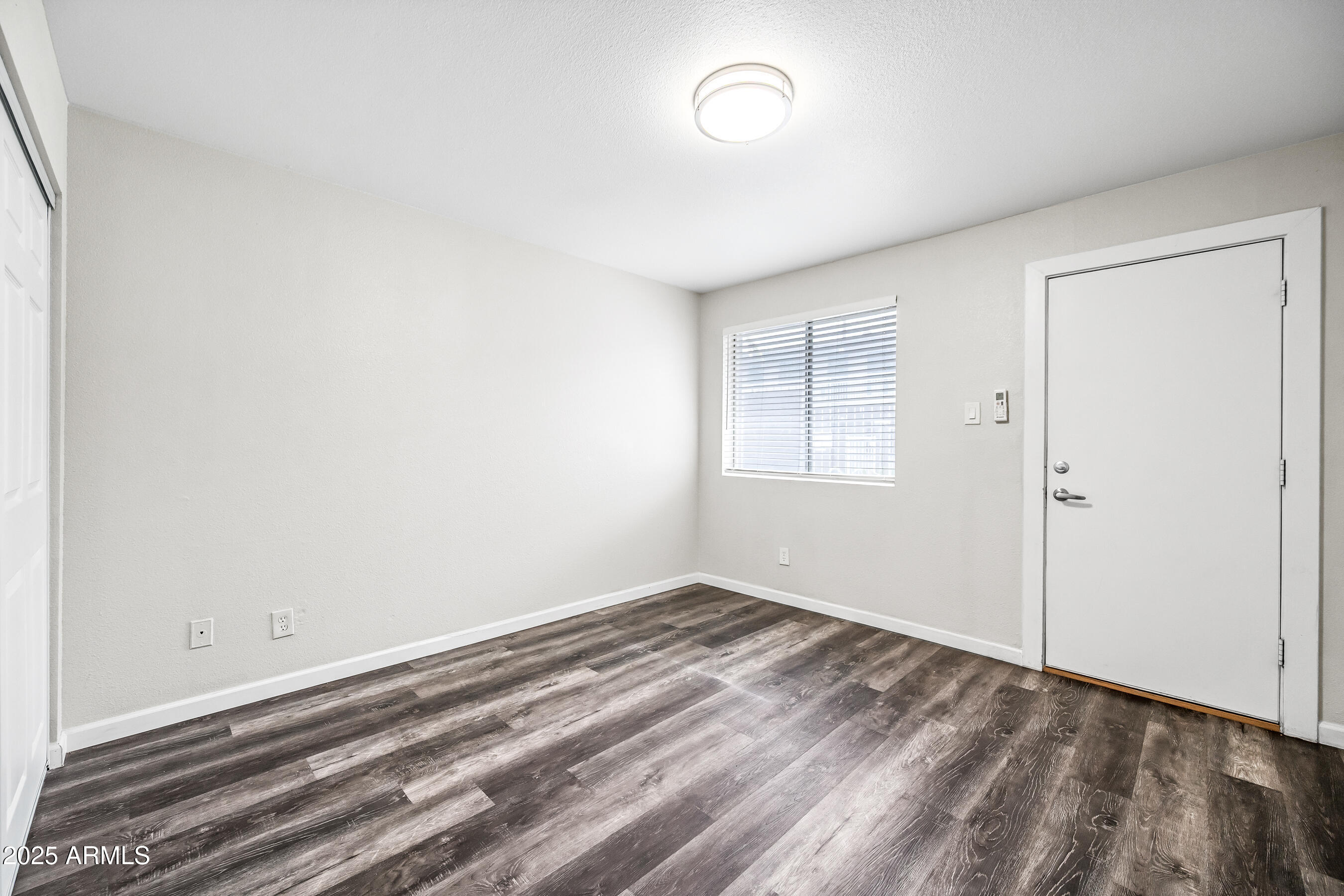3025 North 32nd Street, Unit 10 Phoenix, AZ 85018 - Photo 4 of 21 a view of an empty room with wooden floor and a window