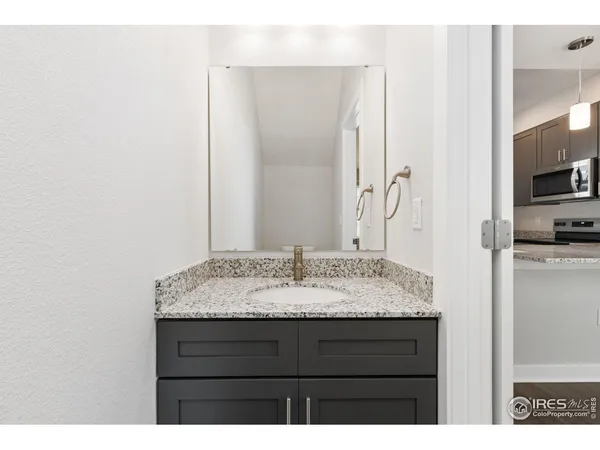 a bathroom with a granite countertop sink and a mirror
