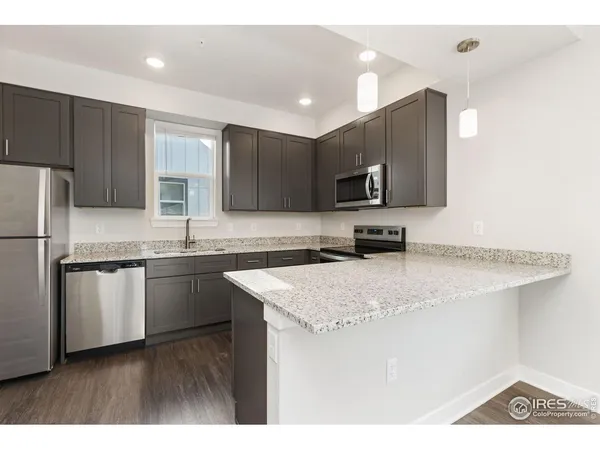 a kitchen with stainless steel appliances granite countertop a sink refrigerator and microwave