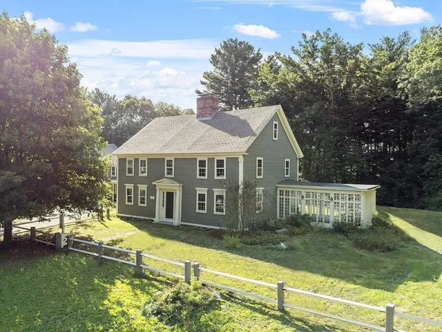 a view of a house with a yard and large tree