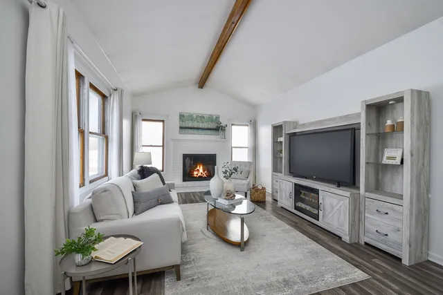 a living room with furniture a flat screen tv and a fireplace