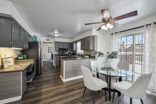 a view of a dining room with furniture a kitchen and chandelier