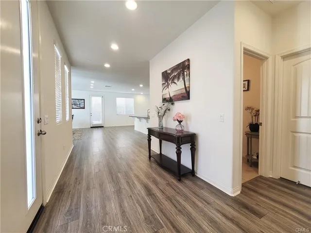 a view of a hallway with wooden floor and furniture