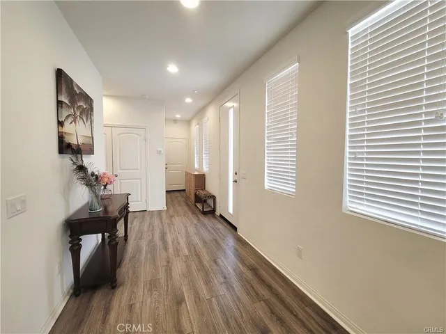 a view of a hallway with wooden floor and a living room