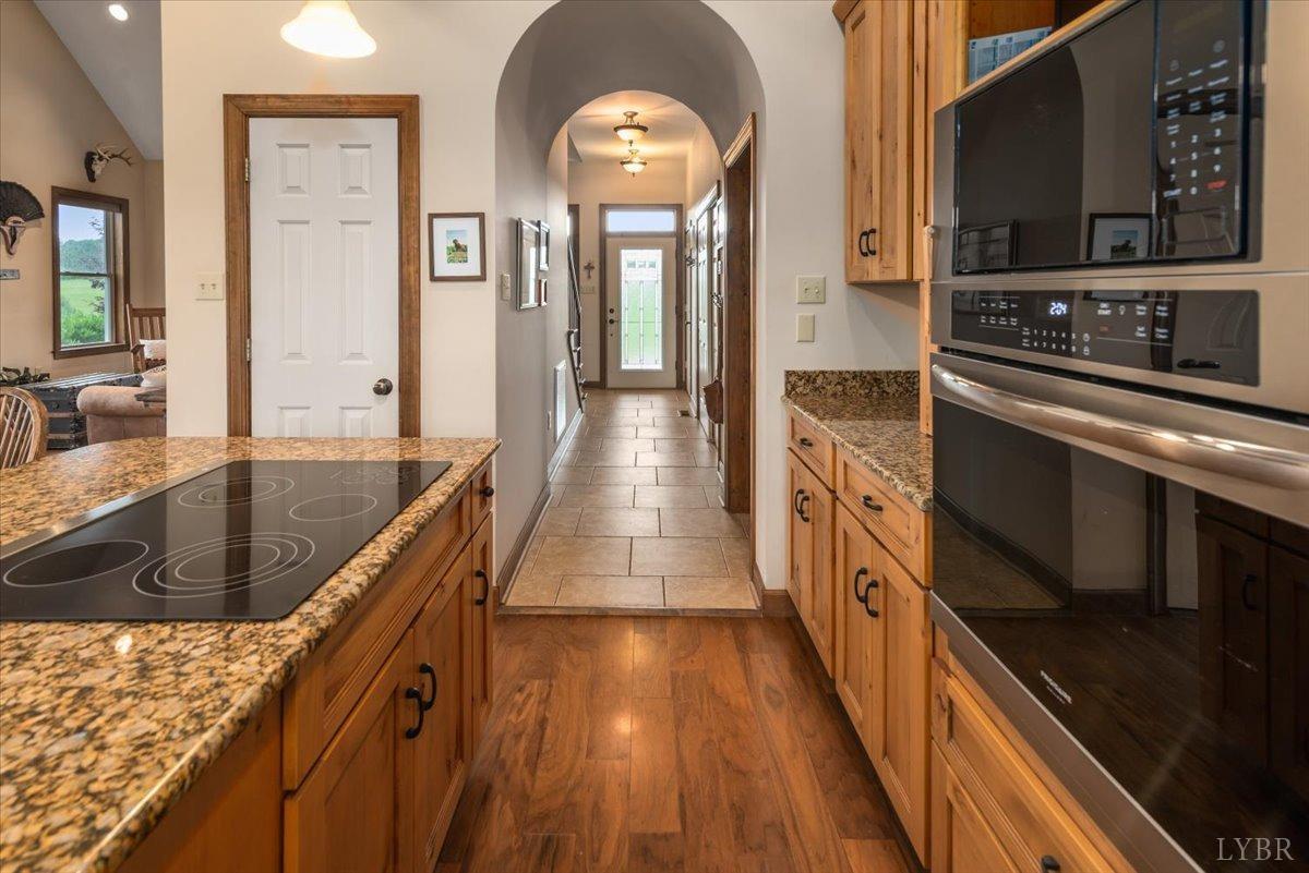 566 White Tail Road Concord, VA 24538 - Photo 16 of 25 a kitchen with stainless steel appliances granite countertop a lot of counter space and wooden floors