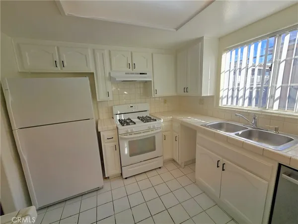 a kitchen with white cabinets sink and white appliances
