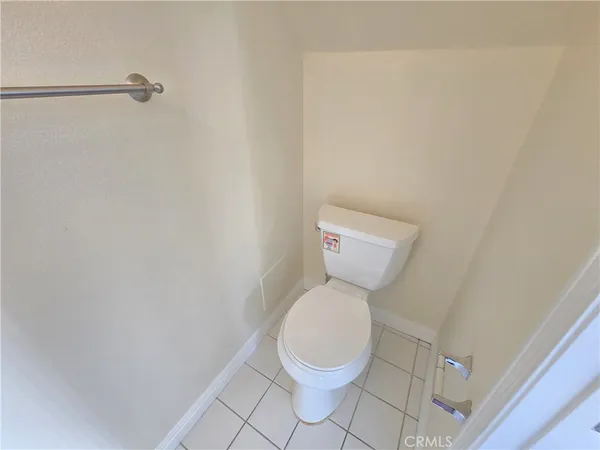 a white toilet sitting next to a white wall
