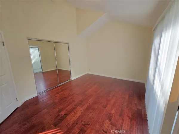 an empty room with wooden floor and entrance