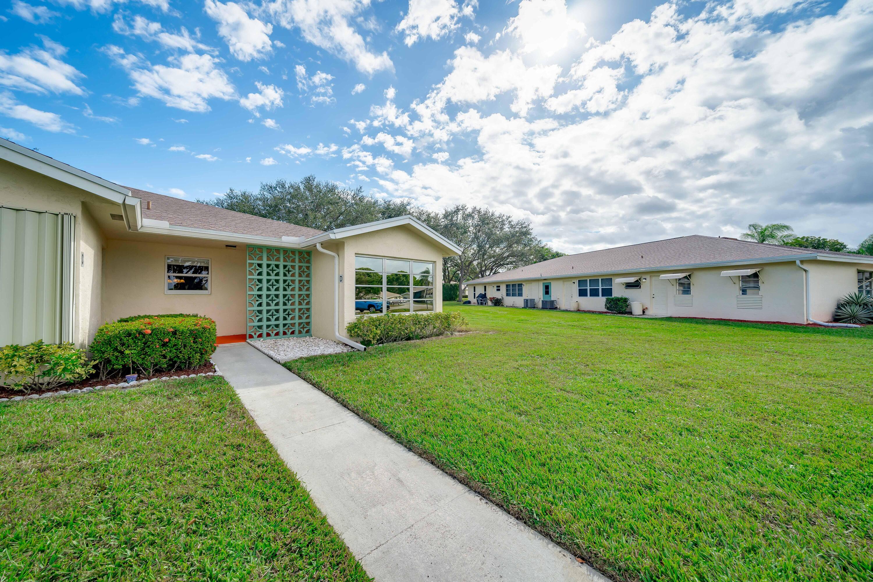 14240 Nesting Way, Unit D Delray Beach, FL 33484 - Photo 29 of 45 a front view of a house with garden