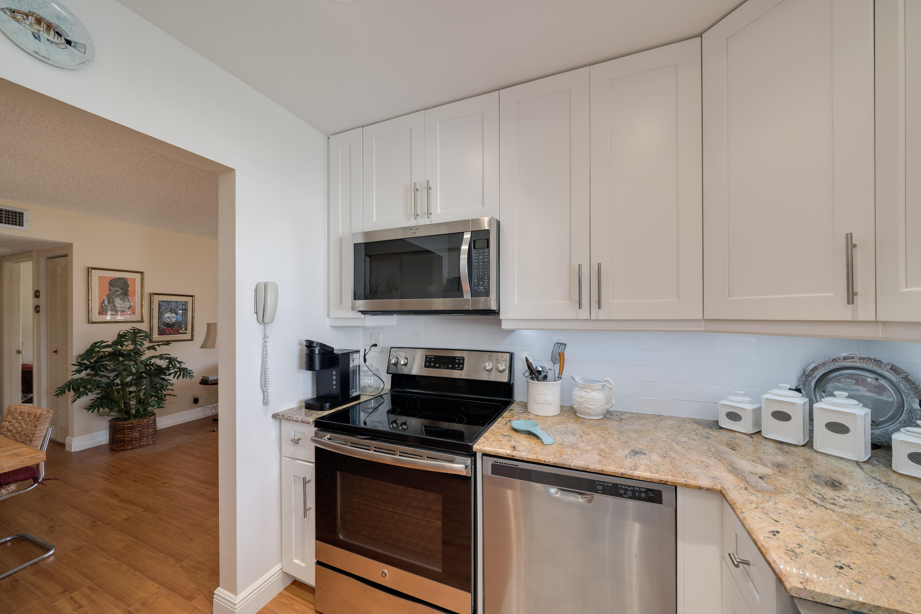 14240 Nesting Way, Unit D Delray Beach, FL 33484 - Photo 4 of 45 a kitchen with granite countertop a sink and a stove top oven