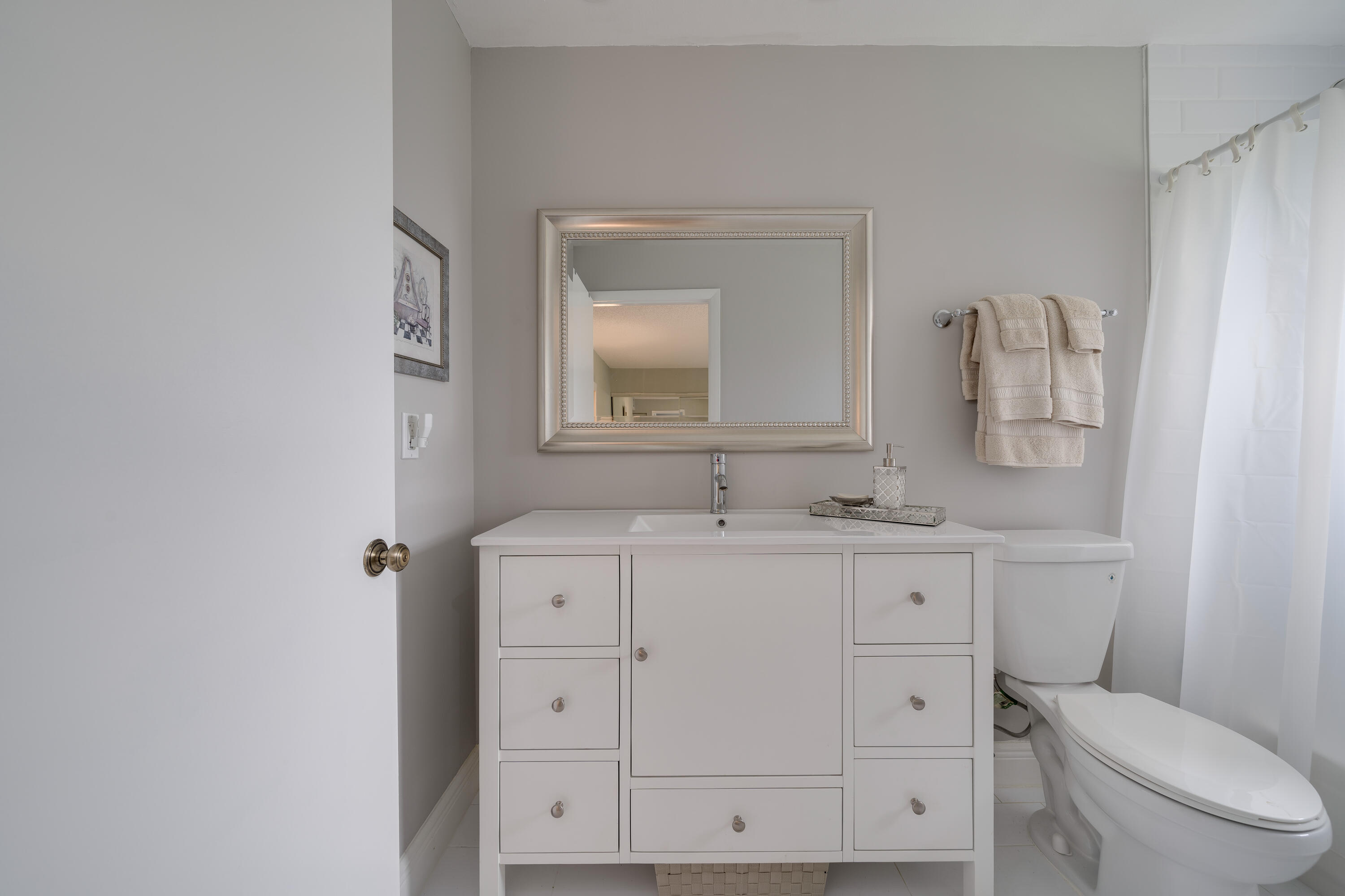14240 Nesting Way, Unit D Delray Beach, FL 33484 - Photo 8 of 45 a bathroom with a toilet a sink a vanity and mirror