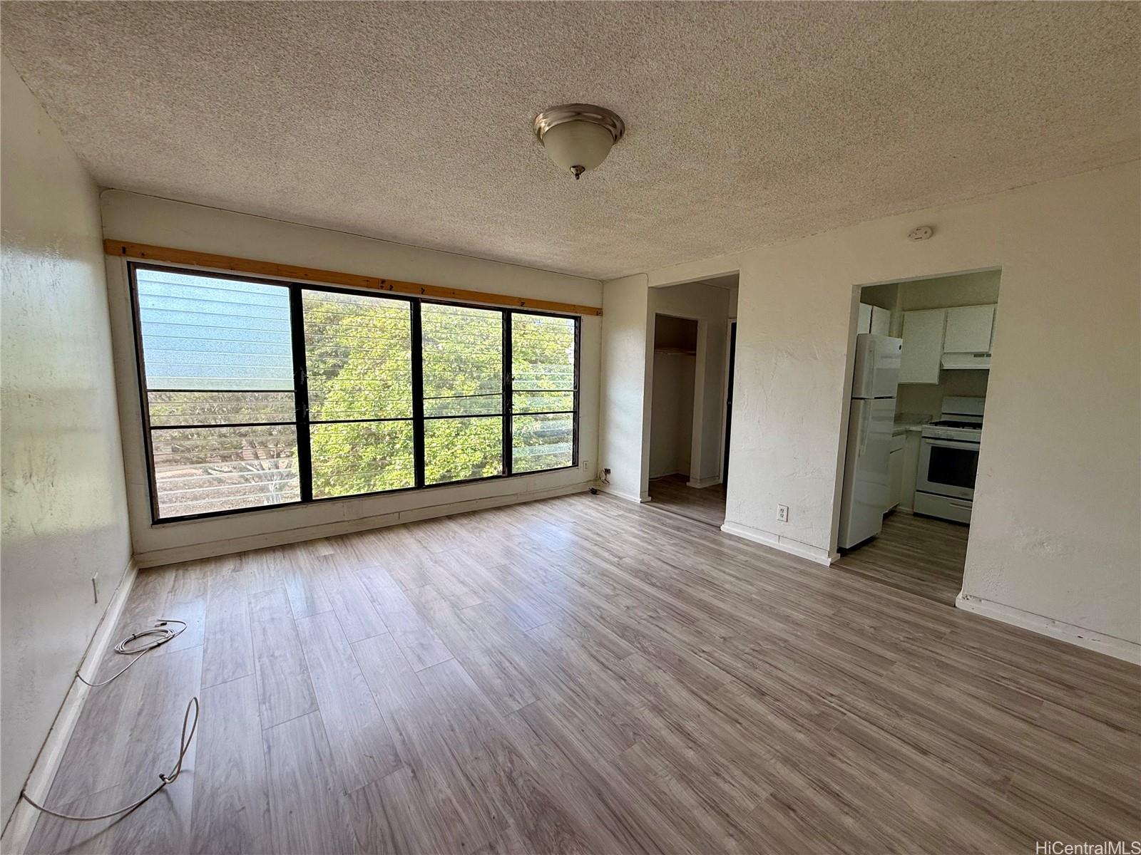 87-134 Helelua Street, Unit A302 Waianae, HI 96792 - Photo 2 of 16 wooden floor in an empty room with a window